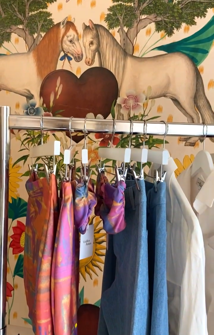 Vieilles Âmes clothing on a rack at ICI Concept Store in Nice with magical wallpaper behind it